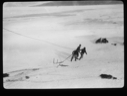 Image of Three men hauling large hook across snow